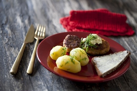 Frikadeller og kartofler på en rød tallerken